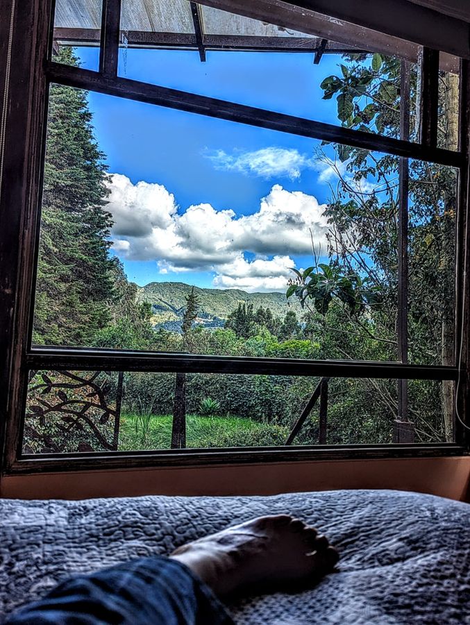 La cama frente al ventanal, con la montaña al fondo